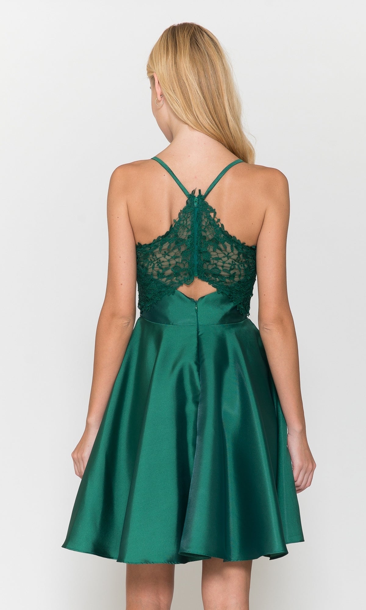 A woman is seen from behind wearing the Lace-Back Short A-Line Homecoming Dress 8698, featuring a green flared satin skirt and lace detailing on the back, set against a plain background.